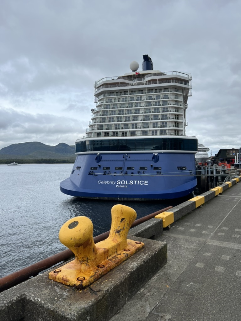 Celebrity Solstice docked at an Alaskan port under overcast skies